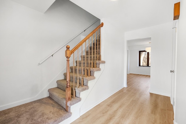 stairway featuring baseboards and wood finished floors