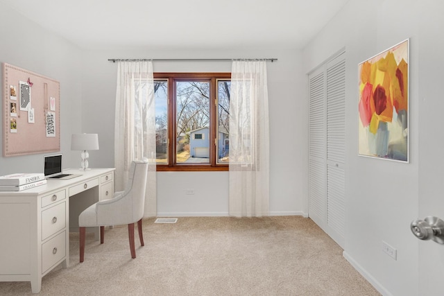 home office featuring light colored carpet, visible vents, and baseboards