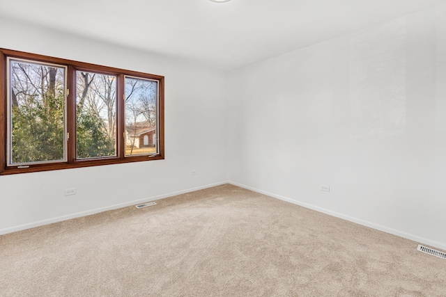 empty room featuring visible vents, baseboards, and carpet floors