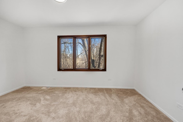 carpeted spare room with visible vents and baseboards