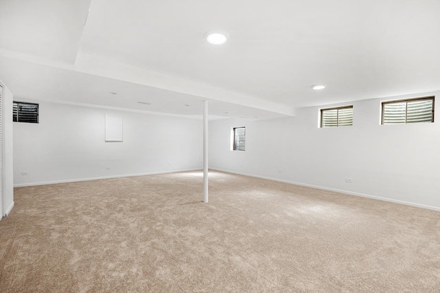 below grade area featuring recessed lighting, baseboards, and light colored carpet