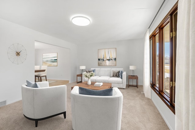 living area featuring visible vents, baseboards, and light colored carpet