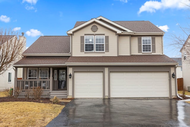 traditional-style home with a garage, a porch, roof with shingles, and aphalt driveway