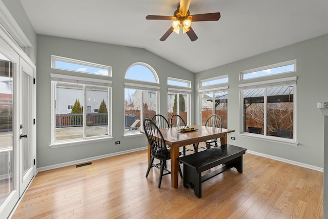 dining space featuring lofted ceiling, visible vents, light wood-style flooring, ceiling fan, and baseboards