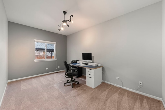 office space featuring light carpet and baseboards