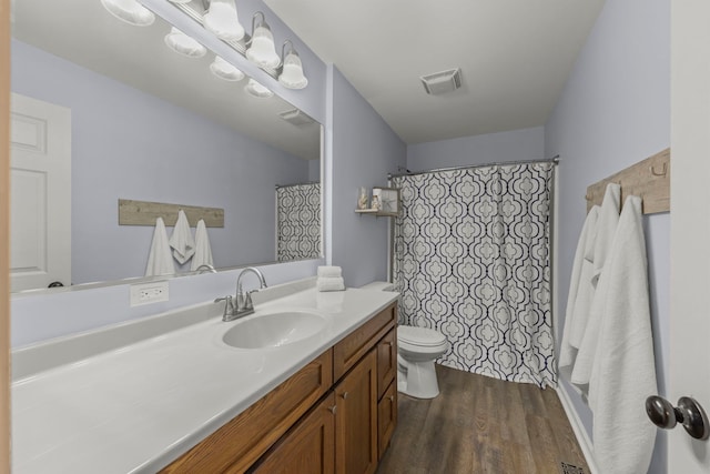 full bathroom featuring visible vents, vanity, toilet, and wood finished floors