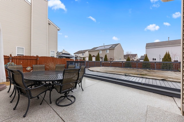 view of patio / terrace with outdoor dining space, fence, and a residential view