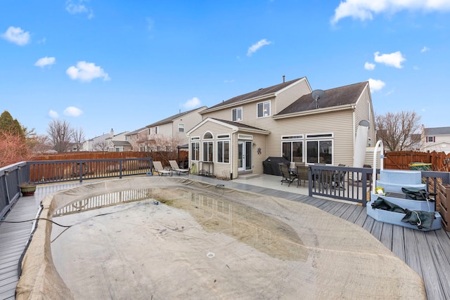 back of property featuring outdoor dining space, a fenced backyard, and a wooden deck