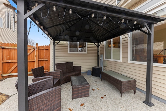 view of patio featuring fence, an outdoor living space, and a gazebo