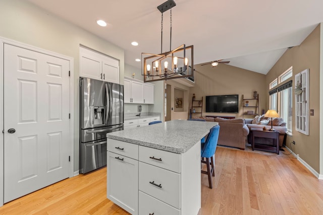 kitchen featuring lofted ceiling, light wood-style flooring, white cabinetry, stainless steel fridge with ice dispenser, and a center island