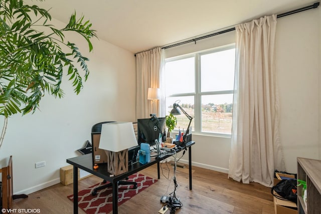 office space with baseboards and light wood-style flooring