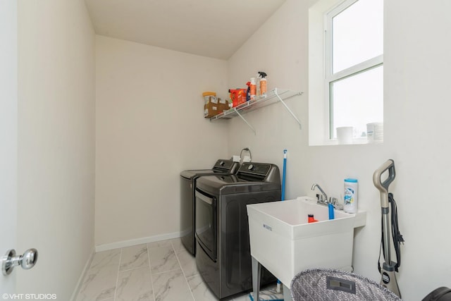 laundry room with laundry area, baseboards, marble finish floor, washer and dryer, and a sink