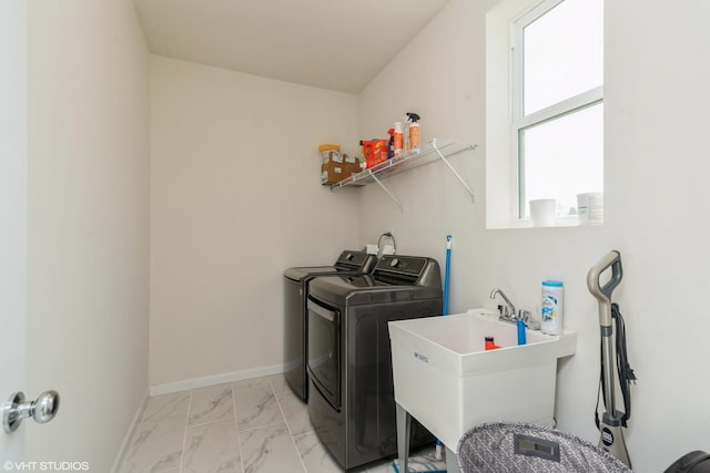clothes washing area with marble finish floor, laundry area, a sink, washing machine and dryer, and baseboards