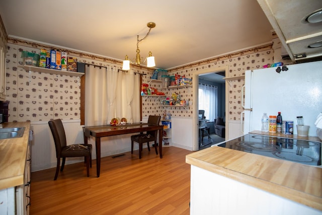 kitchen featuring light wood finished floors, open shelves, butcher block countertops, and freestanding refrigerator