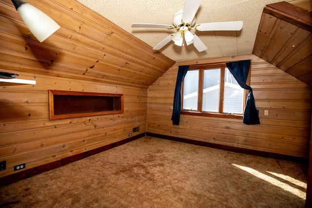 bonus room featuring lofted ceiling, wood walls, and carpet