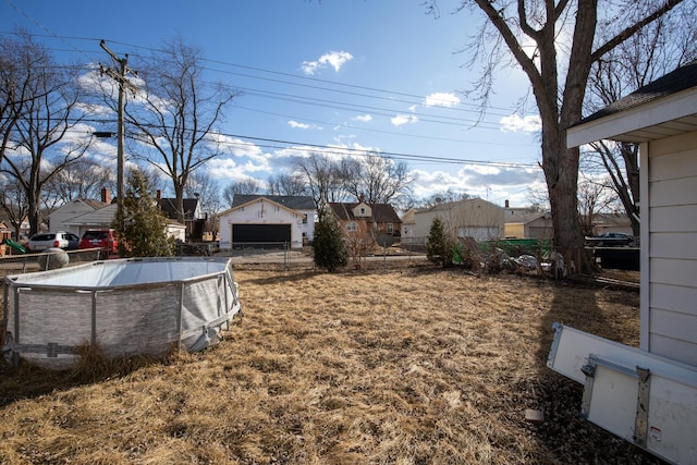 view of yard with fence, an outdoor pool, and an outbuilding