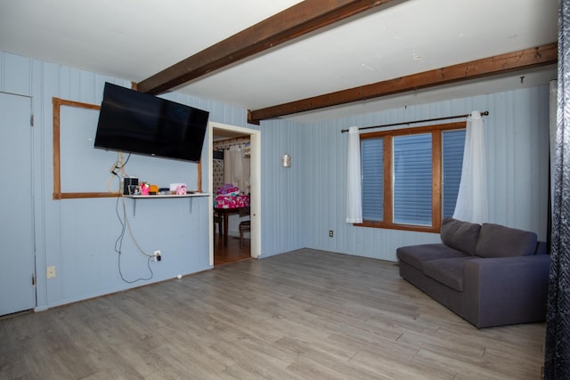 unfurnished room featuring wood finished floors and beam ceiling