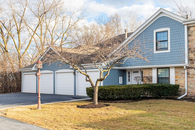 view of front of house featuring stone siding, driveway, and a front yard