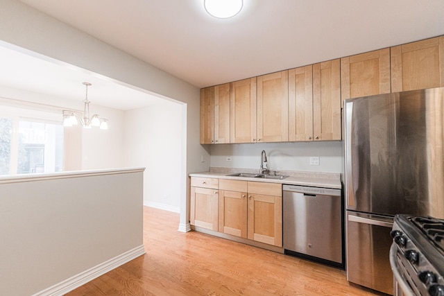 kitchen with light wood-style flooring, a sink, light brown cabinetry, light countertops, and stainless steel appliances