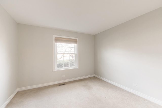 unfurnished room with visible vents, baseboards, and light colored carpet