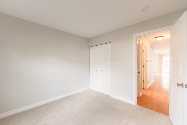 unfurnished bedroom with a closet, baseboards, and carpet flooring