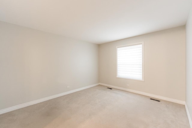 empty room with visible vents, baseboards, and light carpet