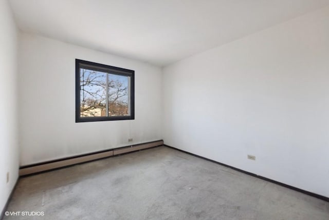 carpeted spare room with a baseboard heating unit