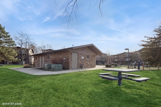 back of house with a yard and brick siding