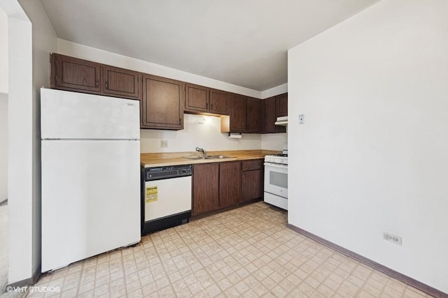 kitchen with white appliances, light floors, light countertops, under cabinet range hood, and a sink