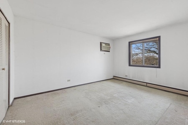 unfurnished bedroom featuring carpet, a baseboard radiator, a closet, a wall mounted AC, and baseboards