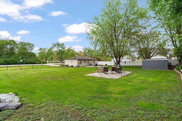 view of yard featuring a patio, a shed, and an outdoor structure