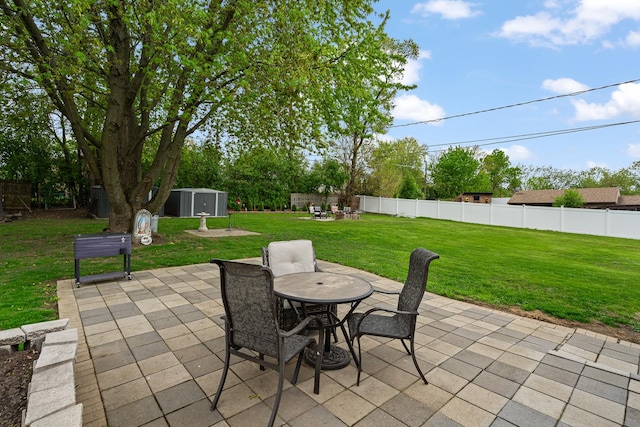 view of patio / terrace featuring a shed, outdoor dining area, and an outdoor structure