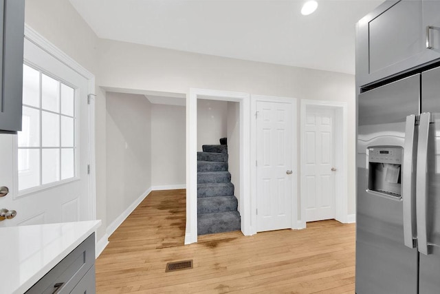 kitchen featuring light wood-style flooring, visible vents, light countertops, gray cabinets, and stainless steel fridge with ice dispenser