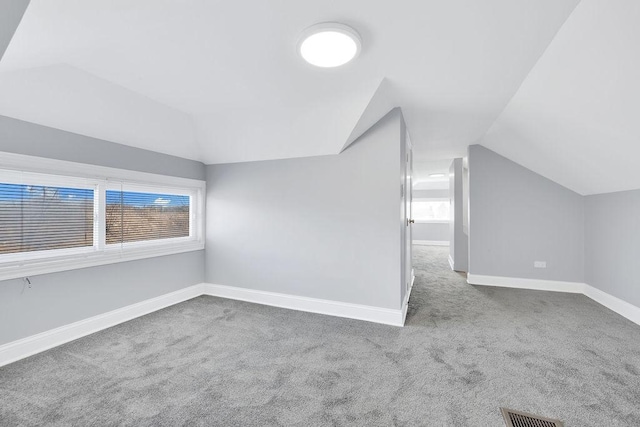 bonus room with a wealth of natural light, lofted ceiling, and visible vents