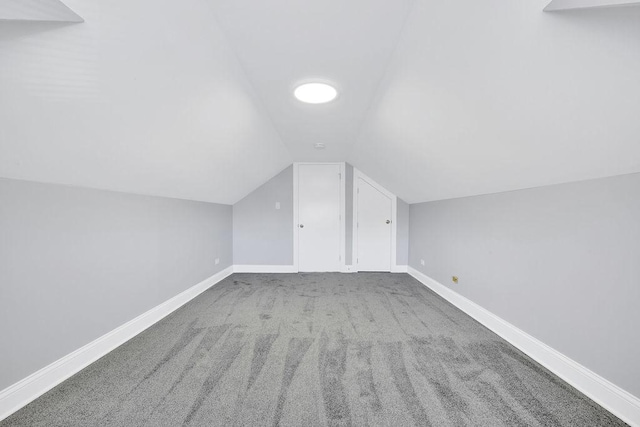 additional living space featuring vaulted ceiling, carpet, and baseboards