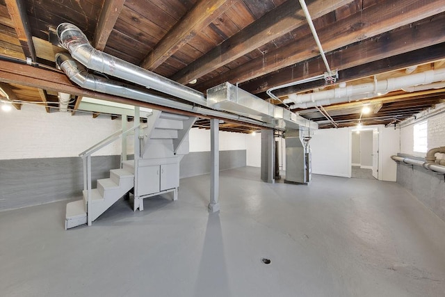 basement featuring heating unit and stairway