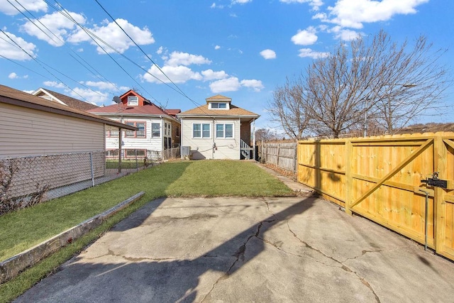 back of house with fence private yard, a gate, and a yard