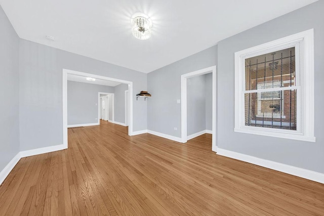 unfurnished room featuring light wood finished floors and baseboards