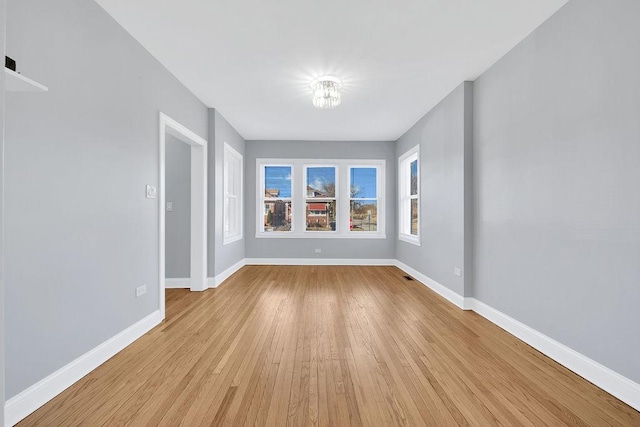 spare room featuring light wood finished floors and baseboards