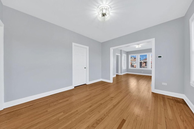 spare room with baseboards and hardwood / wood-style floors