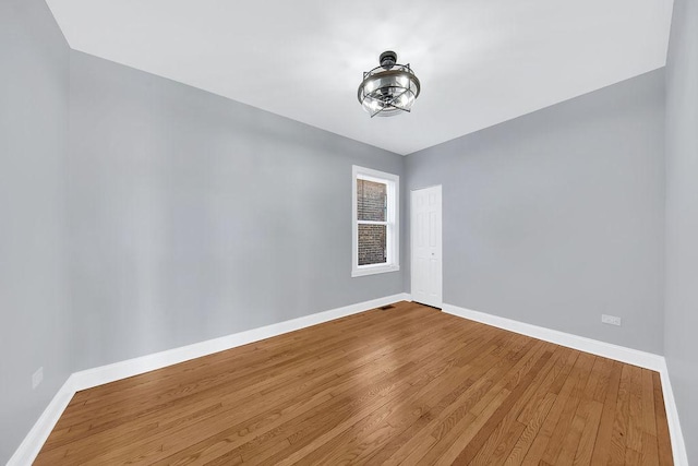 spare room featuring baseboards and wood finished floors