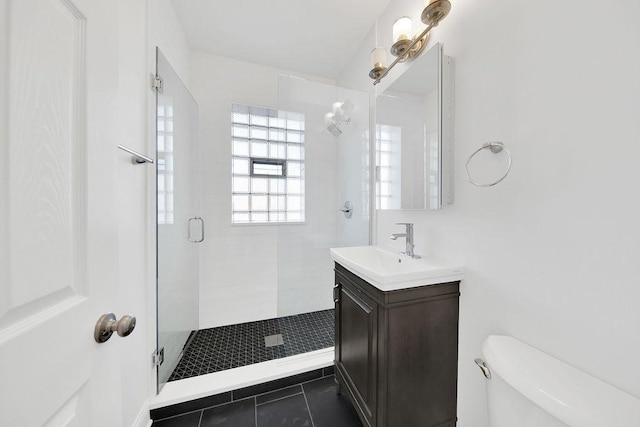 bathroom with vanity, tile patterned flooring, a shower stall, and toilet