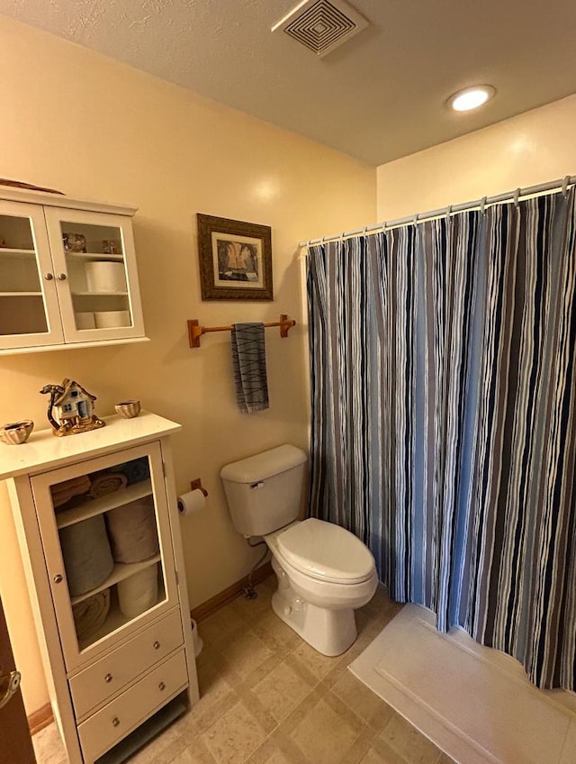 full bath featuring baseboards, visible vents, toilet, a shower with curtain, and tile patterned floors