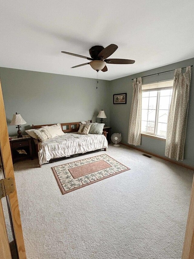 bedroom with carpet floors, visible vents, and a ceiling fan