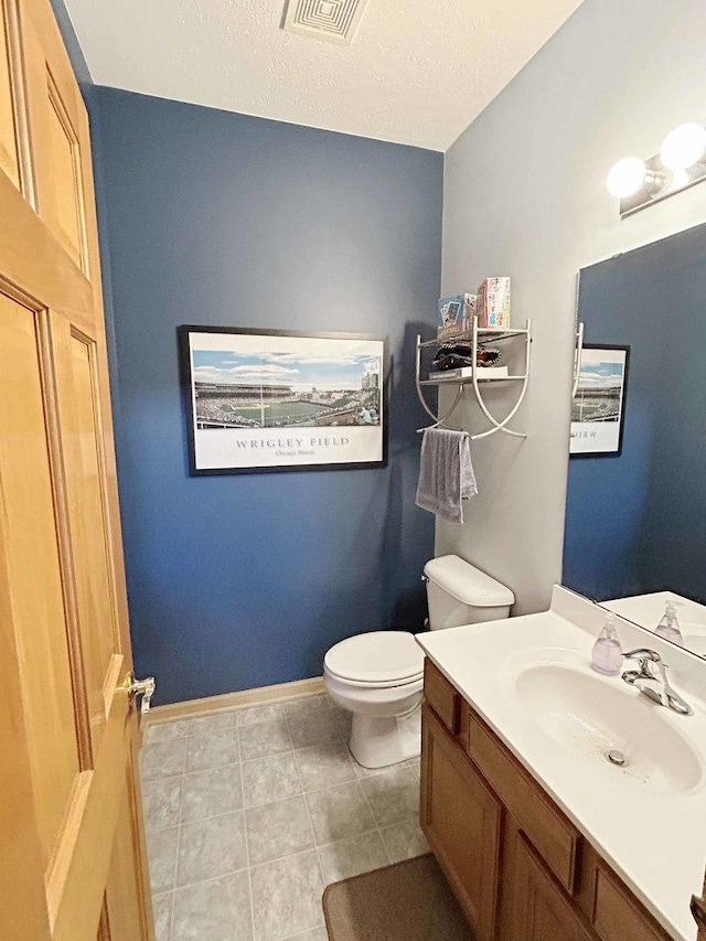 bathroom featuring visible vents, baseboards, toilet, tile patterned flooring, and vanity