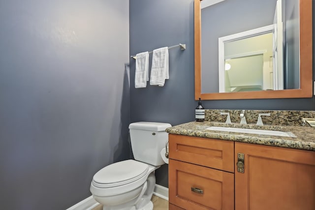 bathroom with toilet, baseboards, and vanity