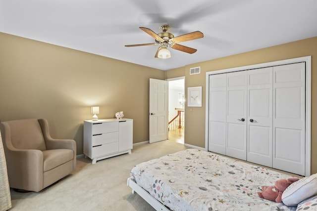 bedroom with a closet, visible vents, a ceiling fan, light carpet, and baseboards