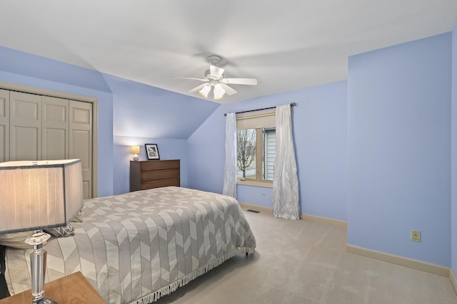 carpeted bedroom with lofted ceiling, visible vents, baseboards, and a ceiling fan