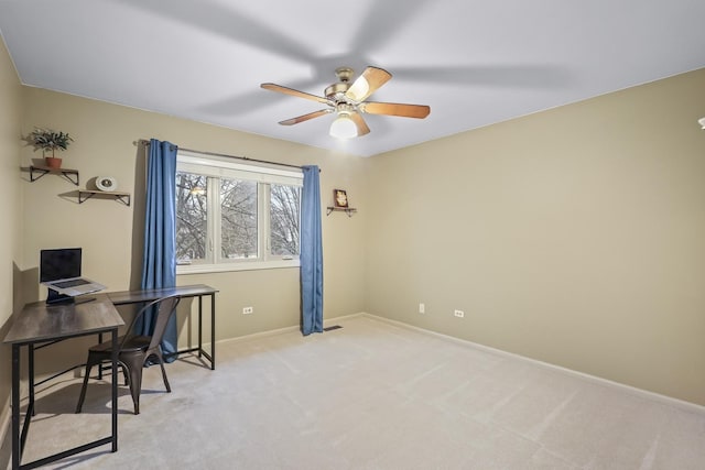 office area with baseboards, a ceiling fan, and light colored carpet