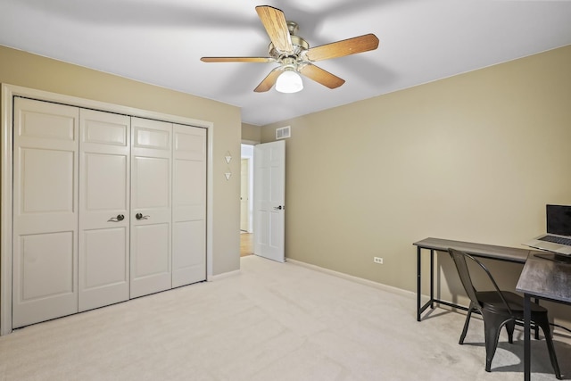 office space featuring light carpet, baseboards, visible vents, and a ceiling fan